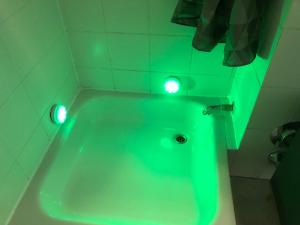 eine grüne Badewanne mit Beleuchtung im Bad in der Unterkunft Apartment in Herborn mit Balkon & Weitblick ins Grüne in Herborn + 17 Fotos