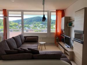 ein Wohnzimmer mit Couch und großem Fenster in der Unterkunft Apartment in Herborn mit Balkon & Weitblick ins Grüne in Herborn