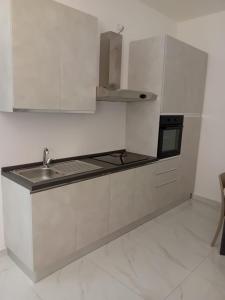 バルレッタにあるIl Don Giovanni Roomのシンクとコンロのある白いキッチン