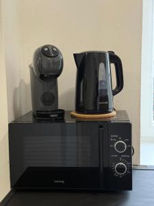 a toaster and coffee pot on top of a microwave at Apartmány U brány in Telč
