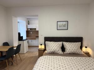 a bedroom with a bed and a table and chairs at Apartmány U brány in Telč