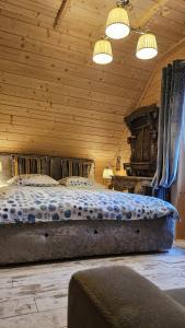 ein Schlafzimmer mit einem großen Bett in einer Holzdecke in der Unterkunft Domki góralskie z sauną i jacuzzi in Kościelisko