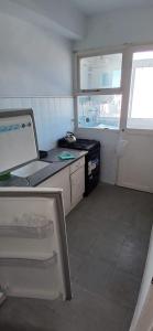 een kleine keuken met een spoelbak en een fornuis bij Frente al mar in Miramar +4 foto's