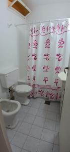 een badkamer met toilet en douchegordijn bij Frente al mar in Miramar