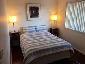 a bedroom with a bed with two lamps on it at Yerrabi Pond in Hall