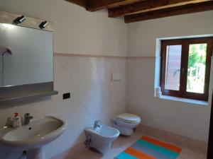 ein Badezimmer mit Waschbecken, Toilette und Spiegel in der Unterkunft Entire House with fireplace and private forest in Pianezze + 29 Fotos