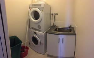 a bathroom with a washing machine and a sink at Yerrabi Pond in Hall