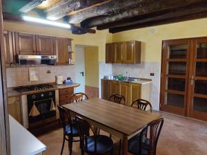 eine Küche mit einem Holztisch und Stühlen darin in der Unterkunft Entire House with fireplace and private forest in Pianezze