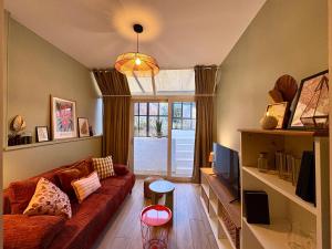 Una sala de estar con un sofá y una ventana. en Grand RDC 6 Pers Arras Stationnement gratuit, en Arras