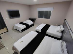a hotel room with two beds and a television at Hotel Doral Inn in Ibagué