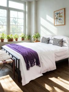 ein Schlafzimmer mit einem großen Bett mit einer lila Decke darauf in der Unterkunft Everlasting Reality in Fort Lee