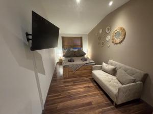 een woonkamer met een bank en een bed bij BOHO Apartment Soleil in Freilassing