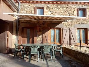 a table and chairs sitting on a patio at Le gîte des Bernadettes in Apchat