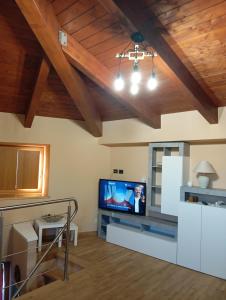 un soggiorno con TV a schermo piatto e soffitti in legno di Loft Mansardato a Catania