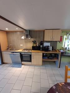 a large kitchen with a stove and a sink at Gîte de la barrière in Libin