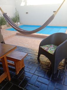 een hangmat, een stoel, een tafel en een zwembad bij Brisas Iguazú II in Puerto Iguazú