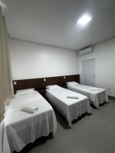 ボン・ジェズス・ダ・ラパにあるVilla Hotelの白いシーツを使用したベッド2台が備わる病室です。