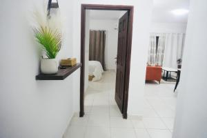 a hallway with a mirror and a room with a couch at SEJOURABIDJAN - Residences Cocody Angré in Abidjan +30 photos