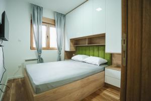 a bedroom with a bed with a green headboard at Grand Residence Zlatibor in Zlatibor +167 photos