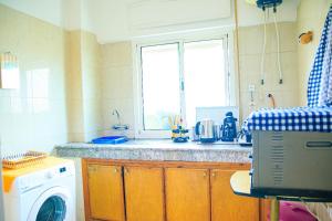 een keuken met een wasmachine en een raam bij CAN Comfort Residence in Temara +9 foto's