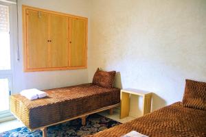 een kamer met 2 bedden, een kast en een tafel bij CAN Comfort Residence in Temara