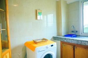 een wasmachine in een keuken met een aanrecht bij CAN Comfort Residence in Temara