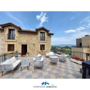 Un patio con sillas y mesas y un edificio. en Aparthotel Marouco, en A Guarda