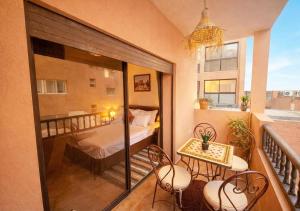 een balkon met een bed en een tafel en stoelen bij Andalous Prestige in Marrakesh