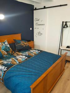 a bed in a room with a blue wall at Le gîte des Bernadettes in Apchat