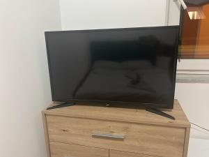 a flat screen tv sitting on top of a wooden dresser at Pansion Most , Mostar in Mostar