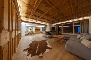 NEW Engadine Alpine Apartment - Pool & Sauna في سان موريتز: غرفة معيشة بها أريكة وطاولة