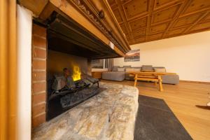 NEW Engadine Alpine Apartment - Pool & Sauna في سان موريتز: غرفة معيشة مع موقد وأريكة