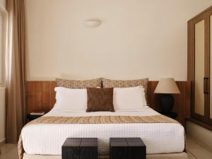 Un dormitorio con una cama grande con almohadas blancas. en San Antonio - Small Luxury Hotels of the World, en Imerovigli