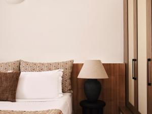 Un dormitorio con una cama con una lámpara al lado en San Antonio - Small Luxury Hotels of the World, en Imerovigli