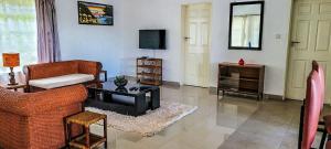 a living room with a couch and a tv at Kabula Lodge in Blantyre