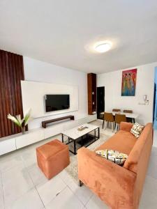 Una sala de estar con un sofá y un televisor. en Villa cosy - Angré soleil 2, en Abiyán
