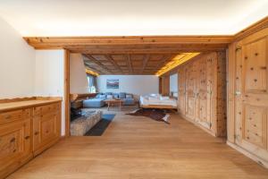 NEW Engadine Alpine Apartment - Pool & Sauna في سان موريتز: غرفة معيشة مع دواليب خشبية وأريكة +26 صورة