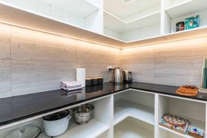 a kitchen with a black counter top and wooden walls at Remarkable Cross Road Retreat in Frankton