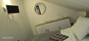 a bedroom with a bed with a mirror on the wall at Apartment Feelgood in Billdal