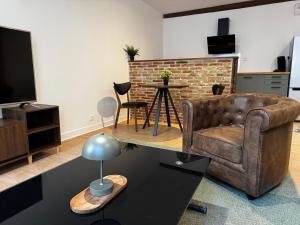 a living room with a couch and a television at L'Escale Saint-Martin in Laon