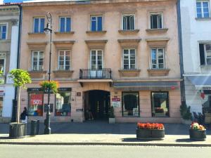 um edifício numa rua com flores em frente em Apartament Nowy Świat em Varsóvia