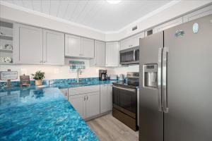 a kitchen with white cabinets and blue counter tops at Amazing Bay view from this Assateague House Condo in Ocean City