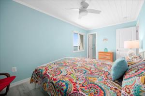 a bedroom with a bed with a colorful blanket at Amazing Bay view from this Assateague House Condo in Ocean City +32 photos