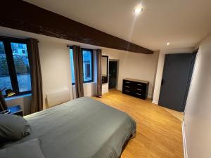a bedroom with a large bed and some windows at L'Escale Saint-Martin in Laon