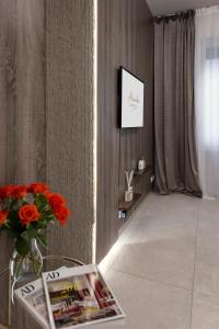 a living room with a vase of flowers on a wall at AlexandraDesignSuite -Eleganza a due passi dal centro in Carpi