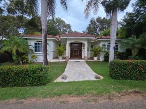 ein weißes Haus mit Palmen im Hof in der Unterkunft Win Villa in Sosúa