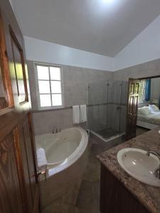 ein Badezimmer mit Badewanne, Waschbecken und Dusche in der Unterkunft Win Villa in Sosúa