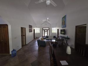 ein Wohnzimmer mit einem Deckenventilator und einem Sofa in der Unterkunft Win Villa in Sosúa