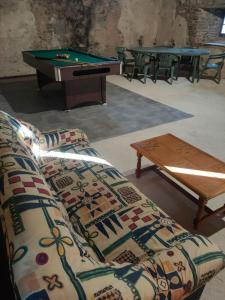 a living room with a couch and a pool table at Le gîte des Bernadettes in Apchat