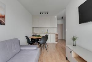 un soggiorno con un divano, un tavolo e una cucina di Trimare Seaside Apartment a Sztutowo
